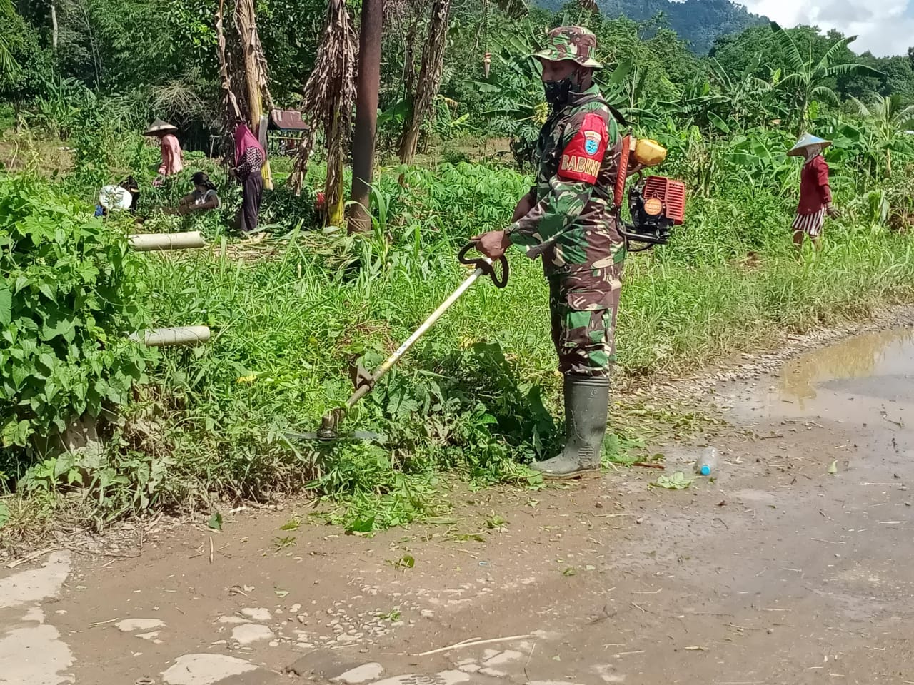 Babinsa Toho Gotong Royong Bersihkan Jalan di Desa Pentek