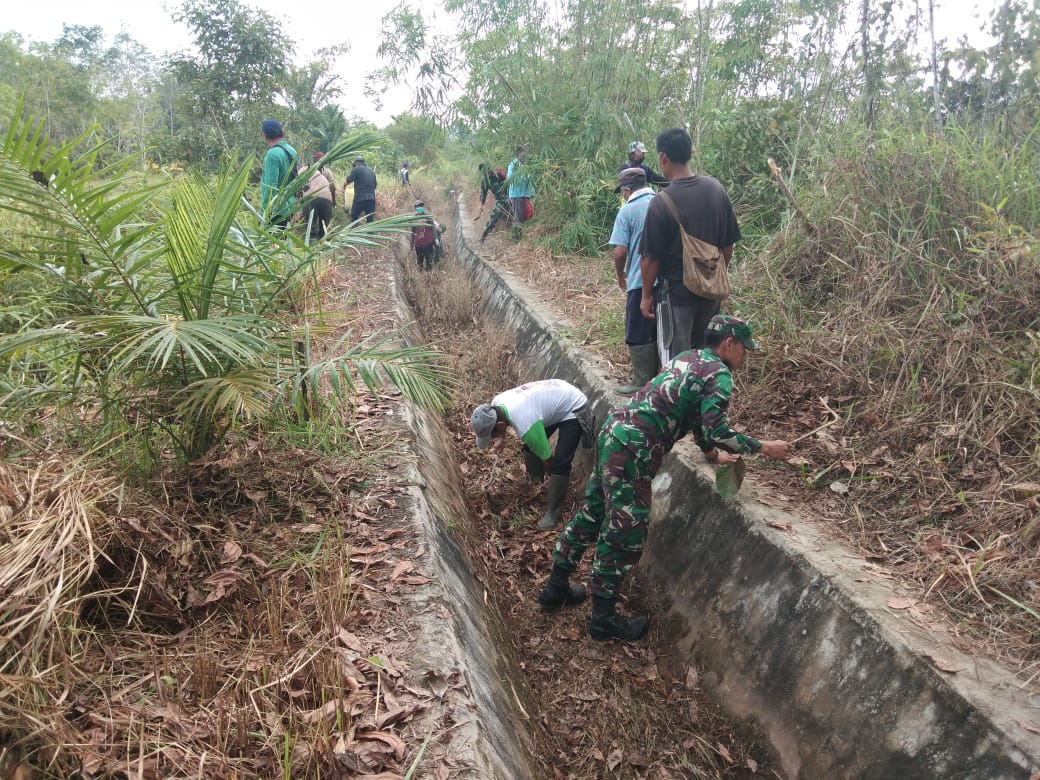 Babinsa dan Warga Tanjam Gotong Royong Bersihkan Saluran Irigasi