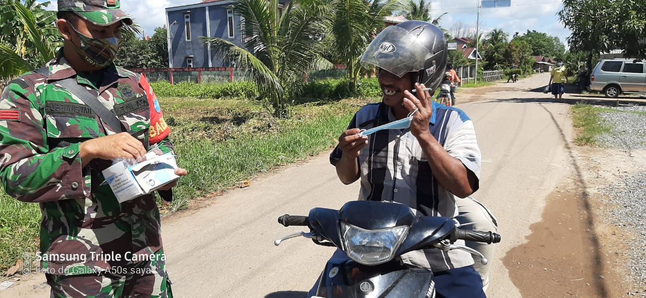 Hindarkan Warga dari Covid-19, Babinsa Koramil Piyuh Bersama Perangkat Desa Bagikan Masker