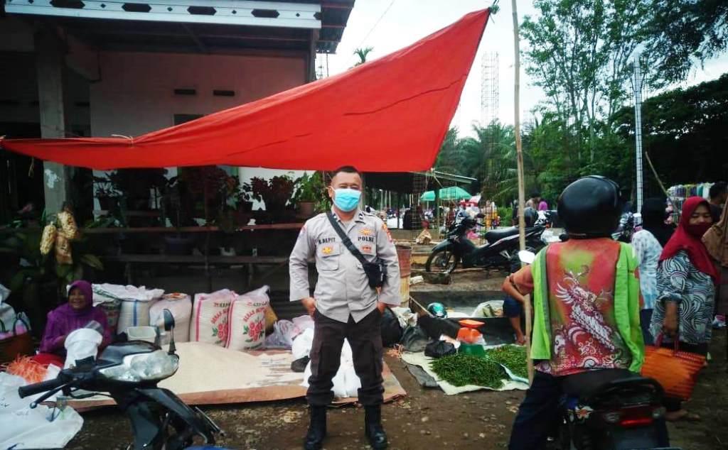 Sambangi Pasar, Bhabinkamtibmas Polsek Karang Tinggi Ingatkan Warga Patuhi Prokes